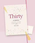 Confetti Hour milestone birthday party invitation, styled flat-lay with envelope