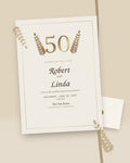 Golden Years 50th anniversary invitation with gold laurels, styled flat-lay