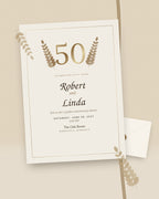 Golden Years 50th anniversary invitation with gold laurels, styled flat-lay